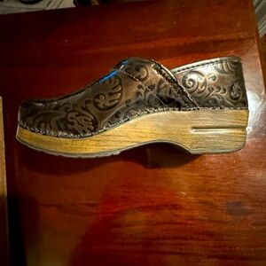 One pair of ladies patent leather Dansko clogs in size 9.
